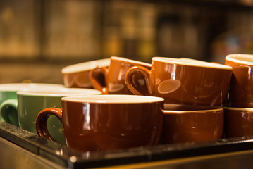 A coffee machine with a large stack of coffee cups.
