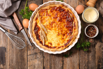 homemade quiche and ingredient on wood background