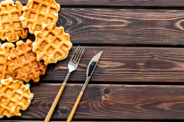 Breakfast with Belgian waffles with knife and fork on wooden background top view mock up