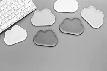 Cloud figures and keyboard for cloud storage on gray background top view mockup