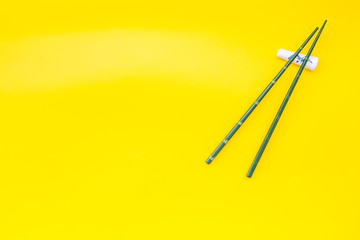 Japanese food cooking set with bamboo sticks for sushi on yellow background top view copy space