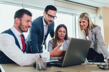 Creative business people working on business project in office using laptop.