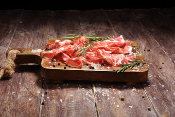 Italian sliced cured coppa with spices. Raw ham. Crudo or jamon with rosemary