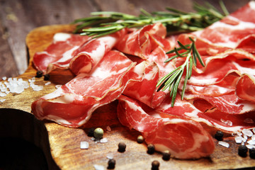 Italian sliced cured coppa with spices. Raw ham. Crudo or jamon with rosemary