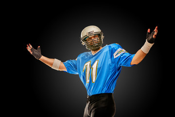 Football player celebrates victory on black background