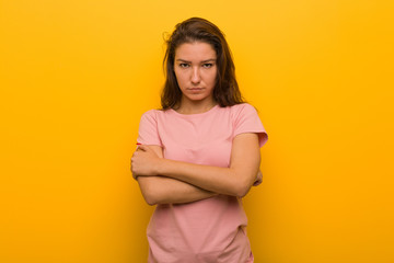 Obraz premium Young european woman isolated over yellow background frowning her face in displeasure, keeps arms folded.