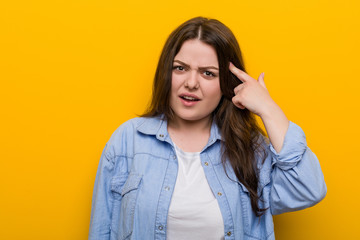 Young curvy plus size woman showing a disappointment gesture with forefinger.