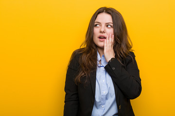 Young plus size caucasian business woman is saying a secret hot braking news and looking aside