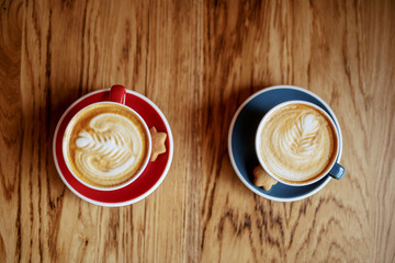 Top view of two cups filled with fresh espresso on table in cafeteria.