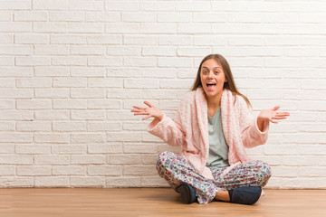 Young woman wearing pajama celebrating a victory or success