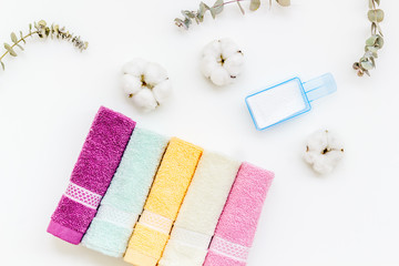 powder for laundry and cotton towels on white background top view