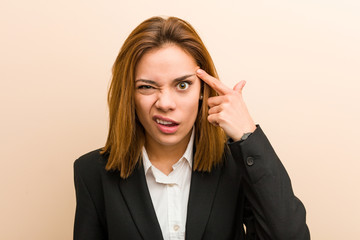 Young caucasian business woman showing a disappointment gesture with forefinger.