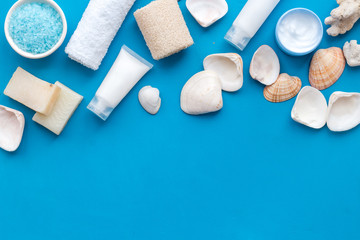 cosmetics with Dead Sea minerals and shells on blue background top view copy space