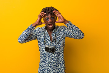 Young black rasta man wearing a vacation look keeping eyes opened to find a success opportunity.