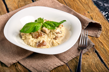 Homemade traditional Italian mushroom risotto on wooden table.