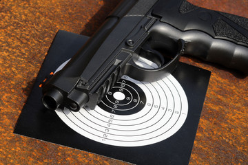 Black air gun with target on the metal grunge background.