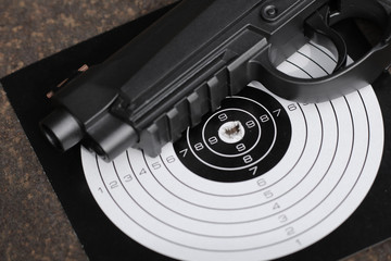 Black air gun with target on the metal grunge background.