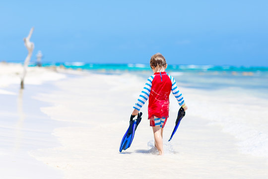 little blond kid boy having fun on tropical beach of Maldives