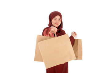 Happy young muslim woman with shopping bag isolated over white background