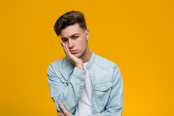 Fototapeta premium Young handsome student wearing a denim shirt who is bored, fatigued and need a relax day.
