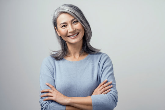 Smiling Asian senior woman with crossed arms