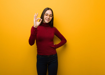 Intellectual young girl cheerful and confident doing ok gesture