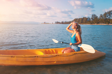 Girl  on kayak  sea at sunset, healthy lifestyle design. Sport, recreation Summer water sport, adventure outdoors. Tropical beach.