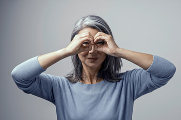 Beautiful Asian woman posing on grey background