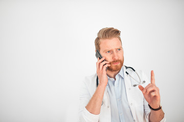 Serious doctor talking on mobile phone.