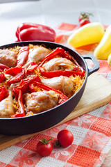 Chicken thighs and legs baked over a bed of rice and red bell pepper