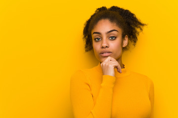 Young black woman closeup over an orange wall