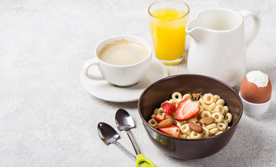Healthy traditional breakfast. Whole grain rings cheerios, coffee, orange juice and egg on table