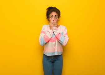 Young black african american girl with blue eyes very scared and afraid hidden