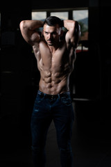 Fototapeta na wymiar Man Showing Abdominal Muscle In Jeans