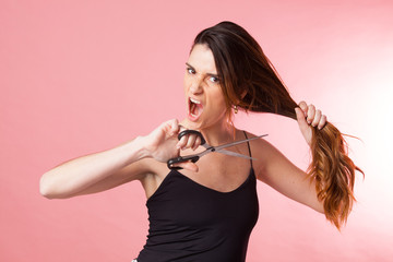 Chica joven intentándose cortar el cabello