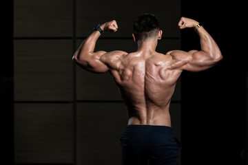 Muscular Man Flexing Muscles Rear Double Biceps Pose