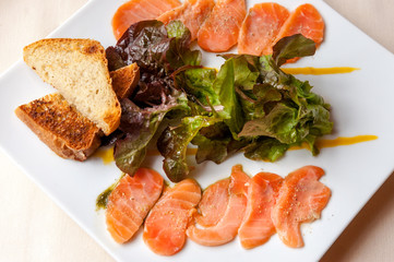 A plate of salmon carpaccio and toasts in French seaside restaurant
