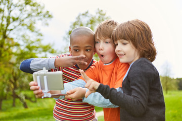 Drei Kinder machen Grimassen für ein Selfie Foto