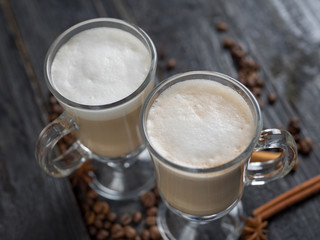 Coffee with milk in a glass on dark wooden background