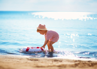 little boy playing at the beach in hat