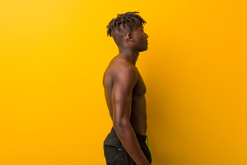 Fototapeta premium Young black man shirtless wearing swimsuit gazing left, sideways pose.