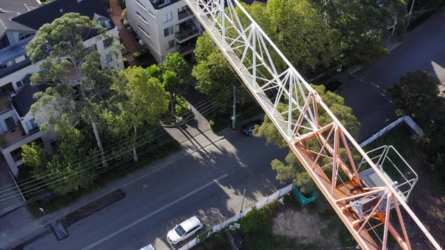 Horizontal working jib of a a tower crane working on an a residential building contruction site - street visible below