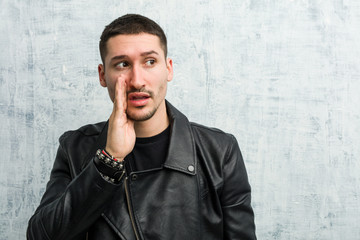 Young rocker man is saying a secret hot braking news and looking aside