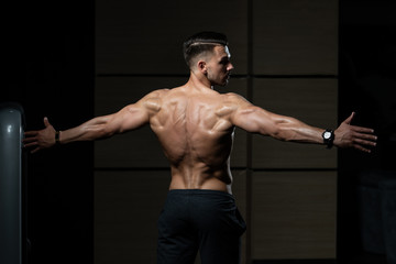 Fototapeta na wymiar Muscular Man Flexing Back Muscles Pose