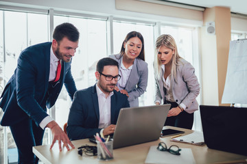 Creative business people working on business project in office using laptop.