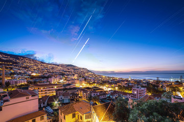 Beautiful long exposure stacked view of the skyline cityscape of the city Funchal on the island Madeira at sunrise in summer with startrails