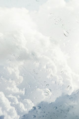 Blurry storm clouds seen through wet window on a rainy day.