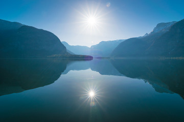 Die Sonne spiegelt sich auf dem Wasser vom See in den Bergen