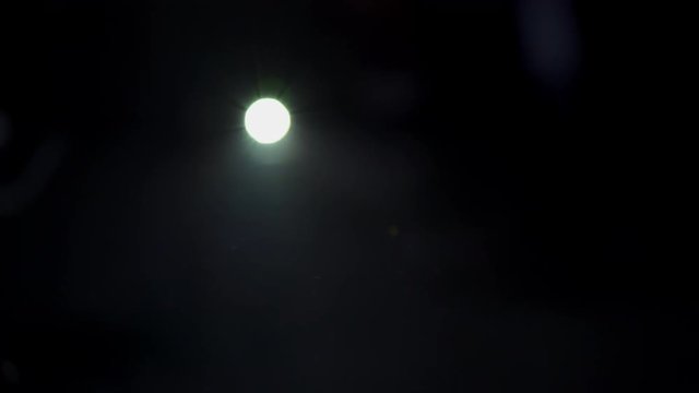 video projector lens spotlight 4K projecting into a dark studio in wide shot with blur Lentille spot vid&eacute;o projecteur 4K