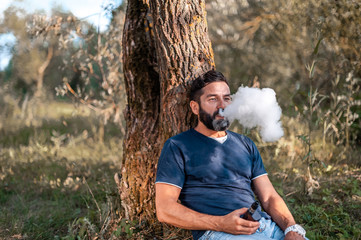 Confident vape man vaping an electronic cigarette. Non-tobacco smoking.